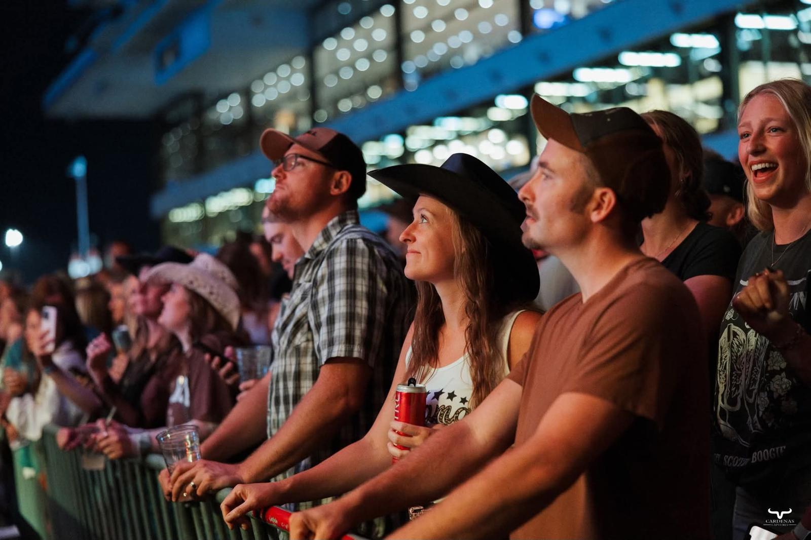 A packed racetrack grandstand at a RATR rodeo